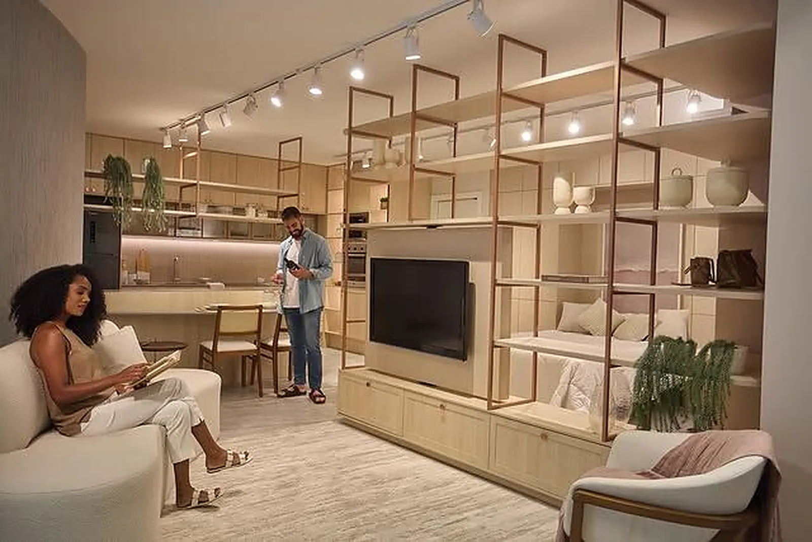 Casal de clientes acompanhado no showroom Italínea Felicità, com painel de TV e estante planejada integrados à cozinha