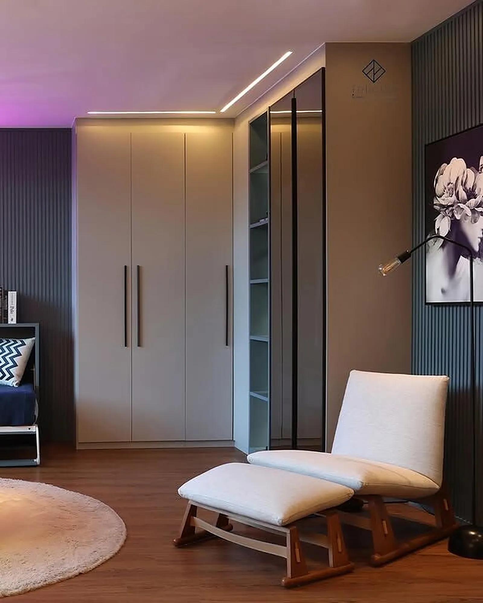 Quarto planejado do showroom com guarda-roupa até o teto, closet envidraçado e poltrona de amamentação